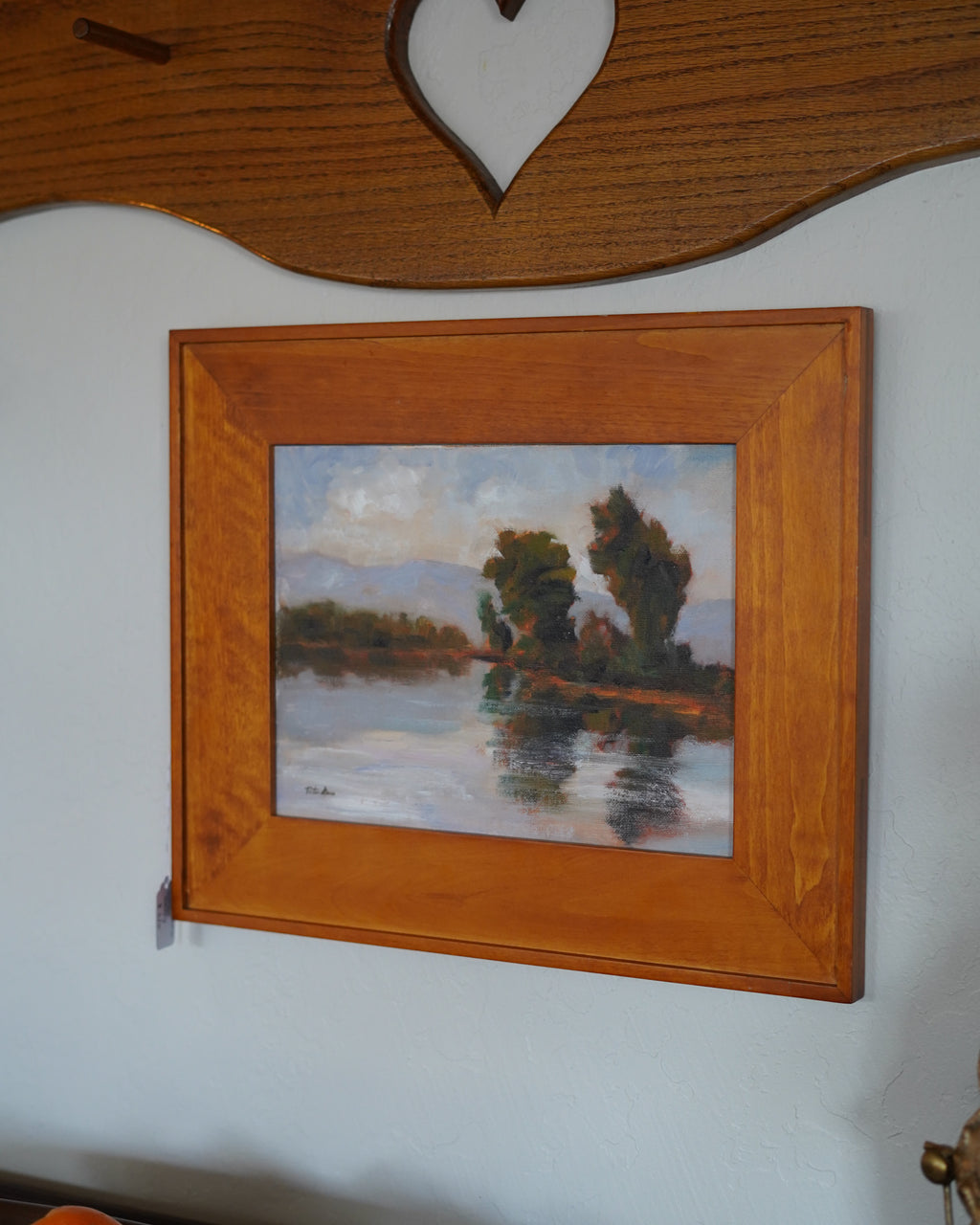 Oil painting of trees reflected in a lake with mountains, Peter Dann
